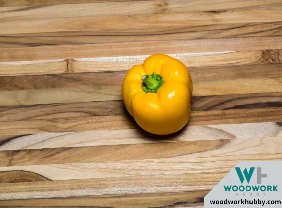 yellow pepper on a teak cutting board